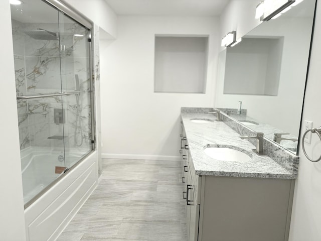 bathroom with vanity and combined bath / shower with glass door