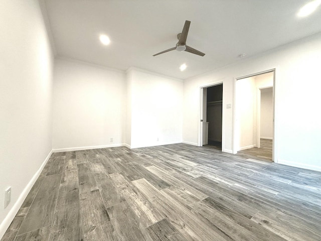 interior space featuring ceiling fan, dark hardwood / wood-style flooring, a closet, and a walk in closet