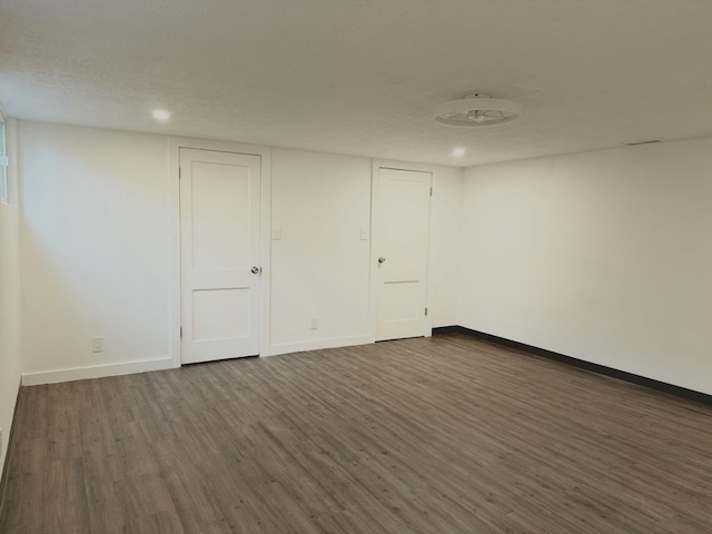 empty room with dark hardwood / wood-style floors and a textured ceiling