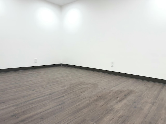 unfurnished room with dark wood-type flooring