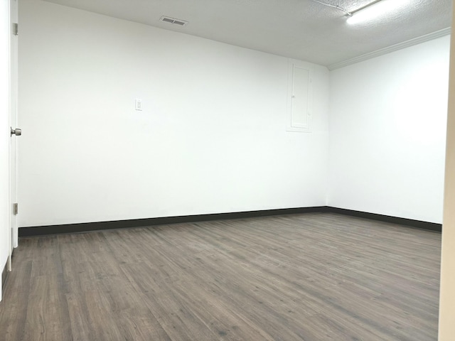 spare room featuring dark hardwood / wood-style flooring and a textured ceiling