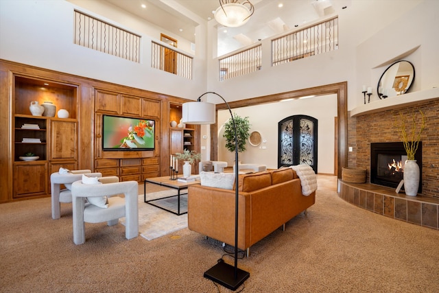 living area featuring built in shelves, a fireplace, french doors, and light colored carpet