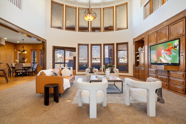 living room with built in shelves, recessed lighting, a high ceiling, and wood finished floors