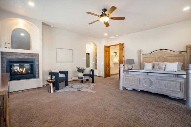 bedroom with carpet floors, arched walkways, recessed lighting, a multi sided fireplace, and baseboards