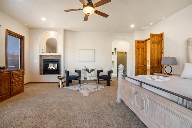 bedroom with arched walkways, recessed lighting, light colored carpet, a multi sided fireplace, and baseboards