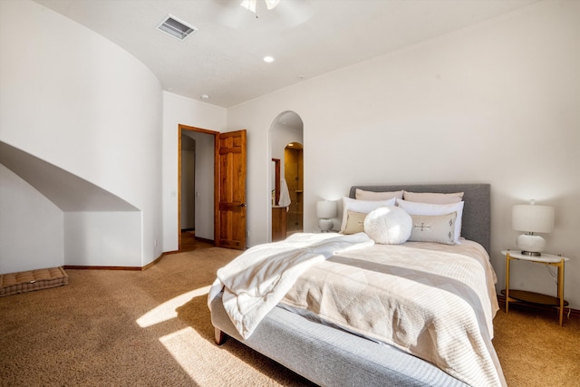 bedroom with arched walkways, carpet flooring, visible vents, and baseboards