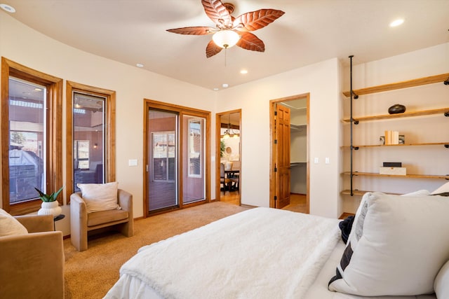 bedroom featuring light carpet, a ceiling fan, access to outside, a walk in closet, and recessed lighting