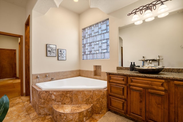 bathroom with a garden tub and vanity