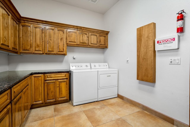 washroom featuring cabinet space, light tile patterned floors, baseboards, and independent washer and dryer