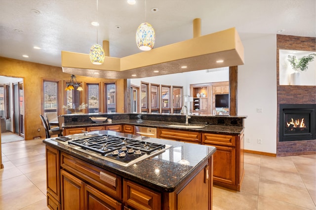 kitchen with light tile patterned floors, a center island with sink, stainless steel appliances, and a sink