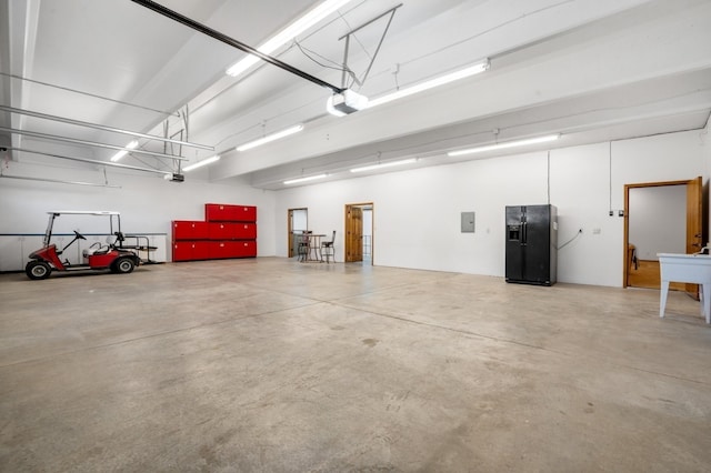 garage featuring a garage door opener and black fridge with ice dispenser