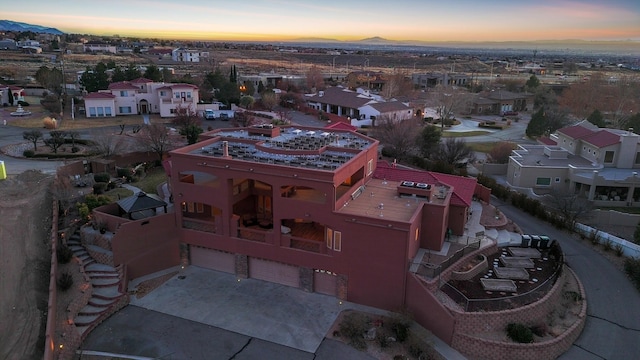 aerial view at dusk featuring a residential view and a mountain view