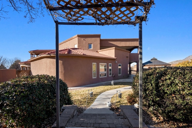 view of home's exterior featuring fence, a tiled roof, and stucco siding