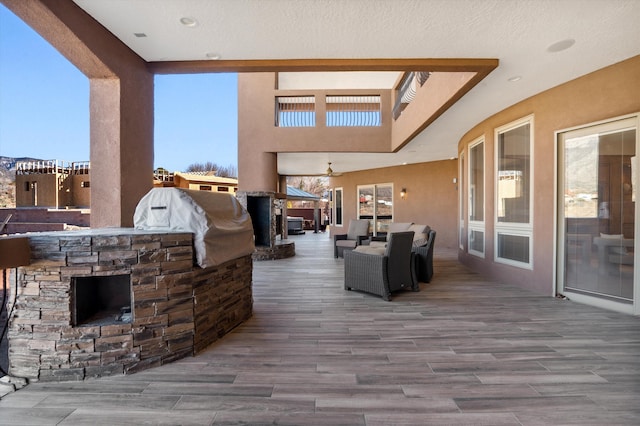 view of patio with a deck, exterior kitchen, and outdoor lounge area