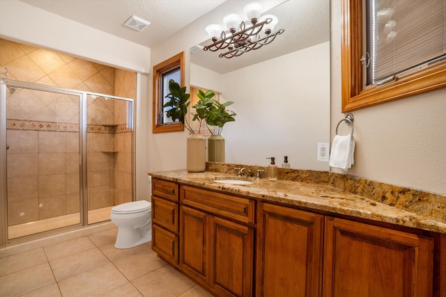 full bathroom with visible vents, toilet, a stall shower, vanity, and tile patterned flooring