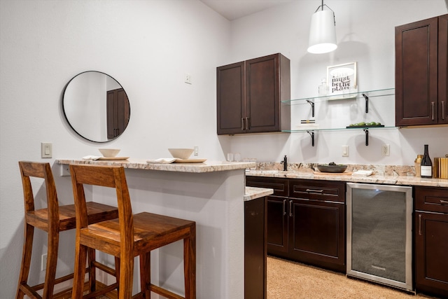 kitchen featuring a breakfast bar, open shelves, dark brown cabinetry, light stone countertops, and fridge