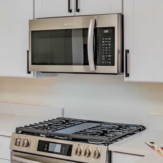 details featuring white cabinetry, stainless steel appliances, and light countertops