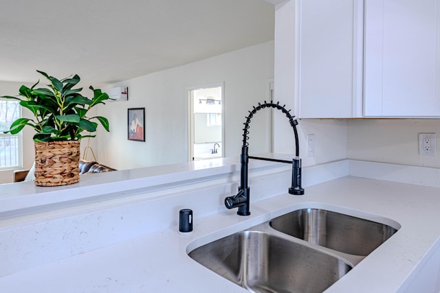 interior details featuring light countertops, white cabinets, and a sink