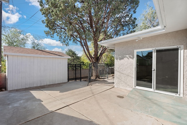 view of patio with an outbuilding and fence