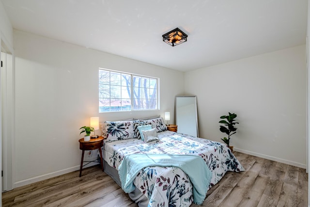 bedroom with wood finished floors and baseboards