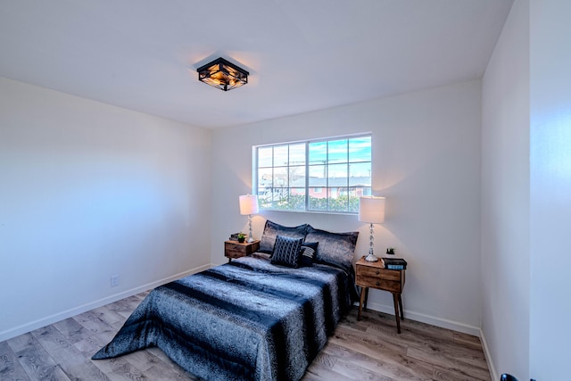 bedroom with wood finished floors and baseboards