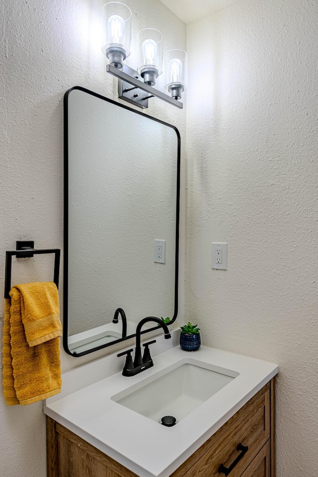 bathroom featuring a textured wall and vanity