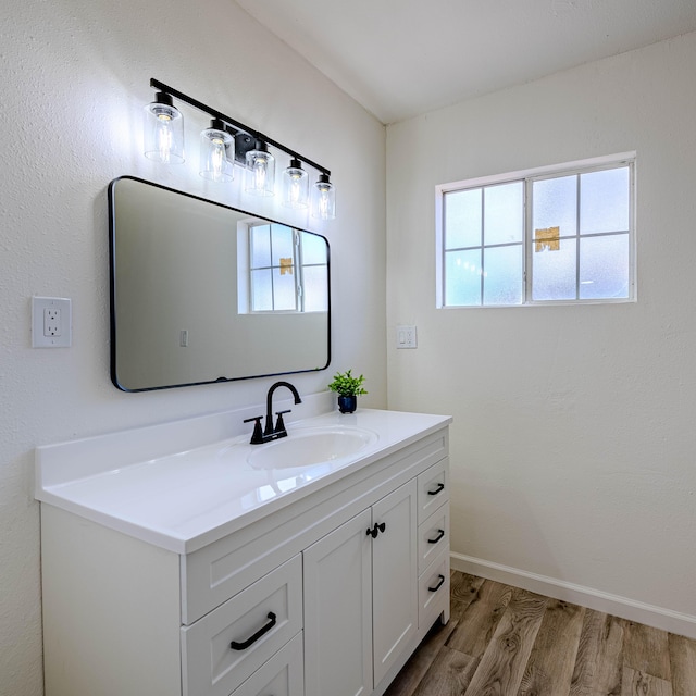 bathroom featuring wood finished floors, vanity, and baseboards