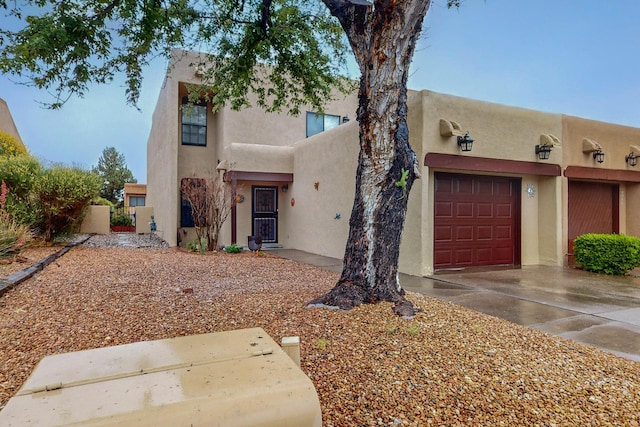 pueblo revival-style home with a garage