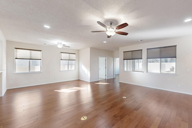 spare room with wood-type flooring, a wealth of natural light, and ceiling fan