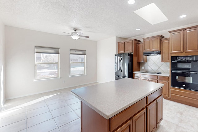 kitchen with light tile patterned flooring, a center island, decorative backsplash, and black appliances