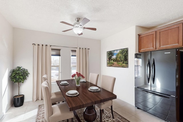 tiled dining space with ceiling fan and a textured ceiling