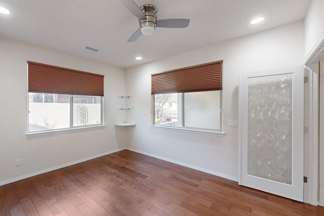 spare room featuring ceiling fan, wood-type flooring, and plenty of natural light