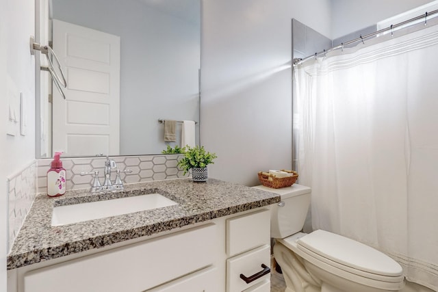 bathroom featuring tasteful backsplash, vanity, and toilet