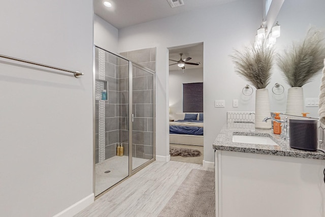 bathroom with walk in shower, ceiling fan, and vanity