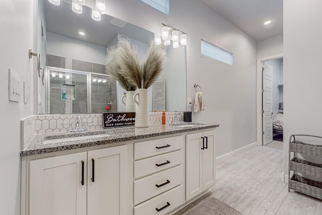 bathroom with a shower with door, vanity, and hardwood / wood-style flooring