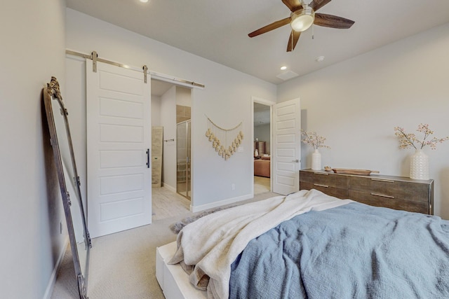 carpeted bedroom featuring a barn door, ensuite bathroom, baseboards, recessed lighting, and ceiling fan