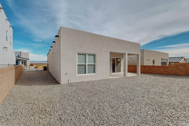 rear view of property with a patio area, a fenced backyard, and stucco siding