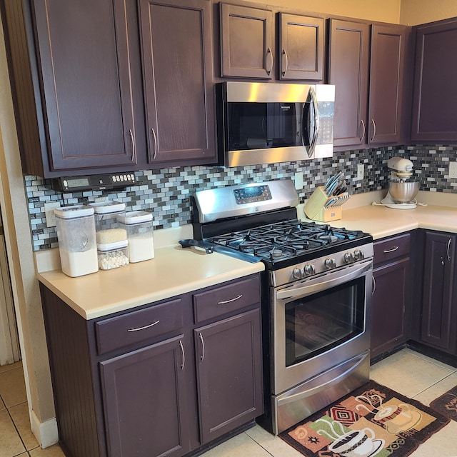 kitchen featuring tasteful backsplash, dark brown cabinetry, appliances with stainless steel finishes, and light tile patterned floors