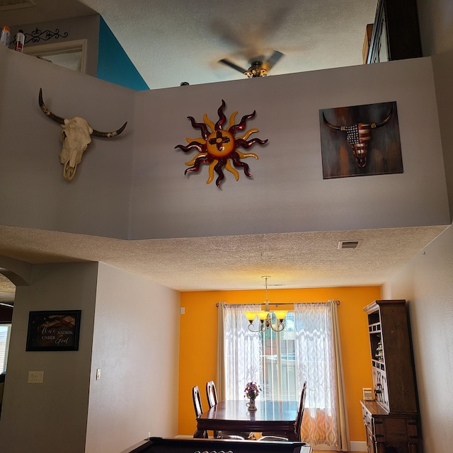 dining space featuring a chandelier and a textured ceiling