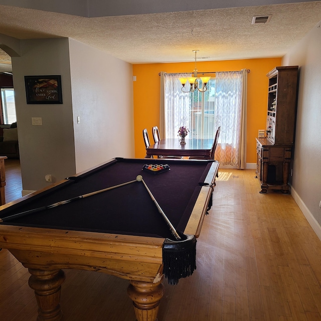 playroom featuring pool table, a chandelier, a textured ceiling, and light hardwood / wood-style floors