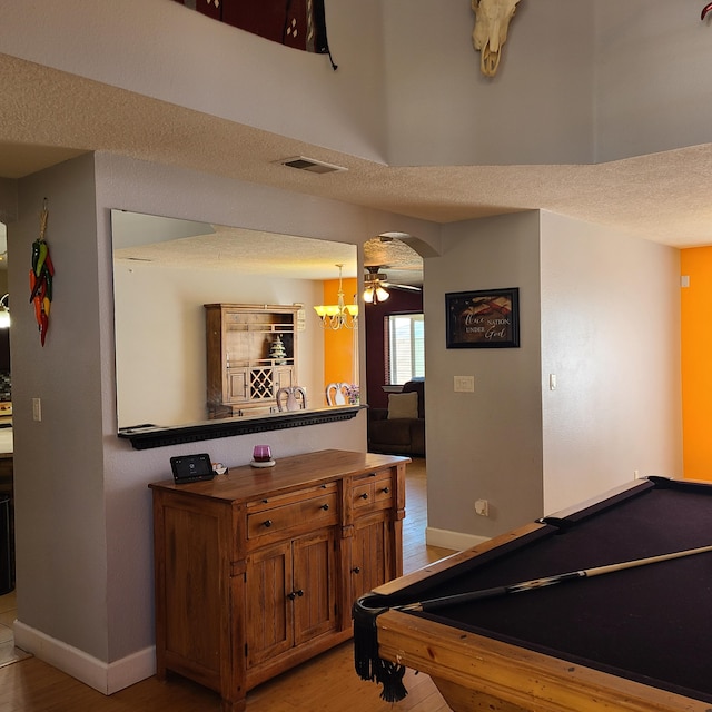 game room with billiards, a textured ceiling, and light wood-type flooring