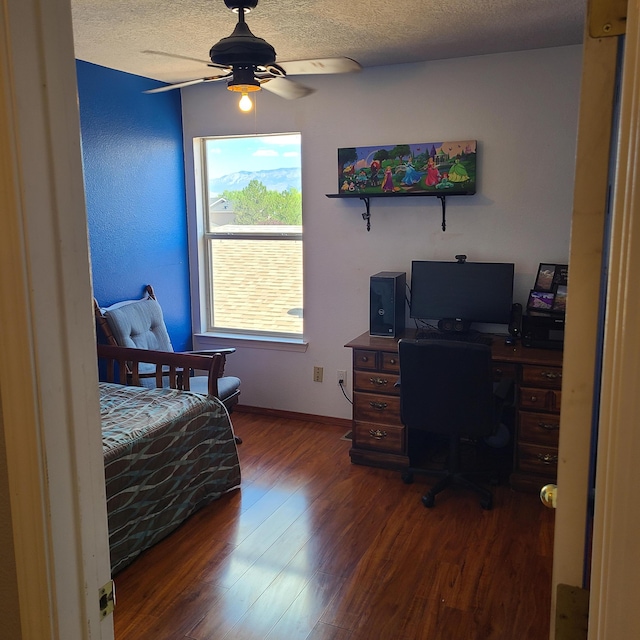 bedroom with a textured ceiling, dark wood-type flooring, and ceiling fan