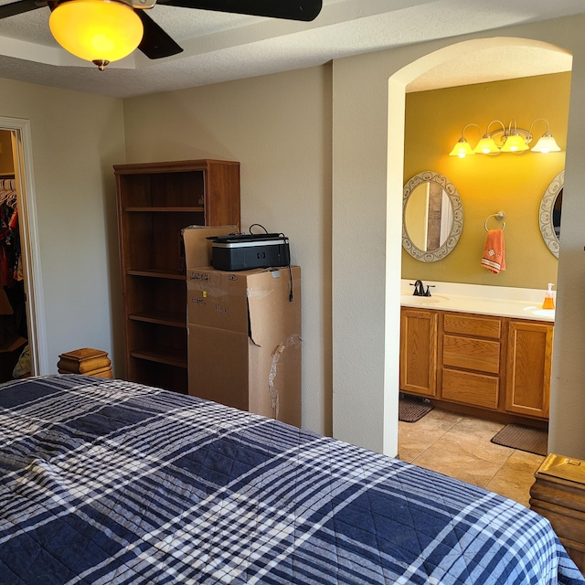 tiled bedroom with sink, a closet, and ceiling fan