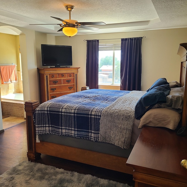 bedroom featuring dark wood-type flooring, ceiling fan, and a textured ceiling