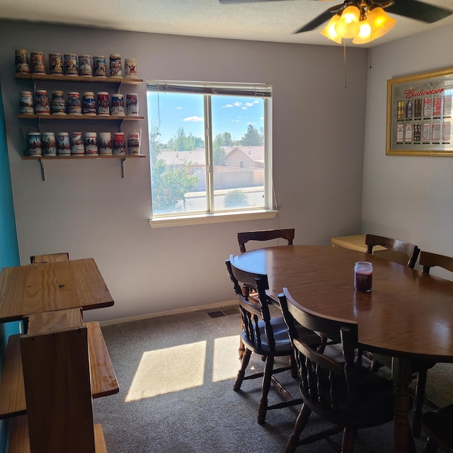 carpeted dining space with ceiling fan