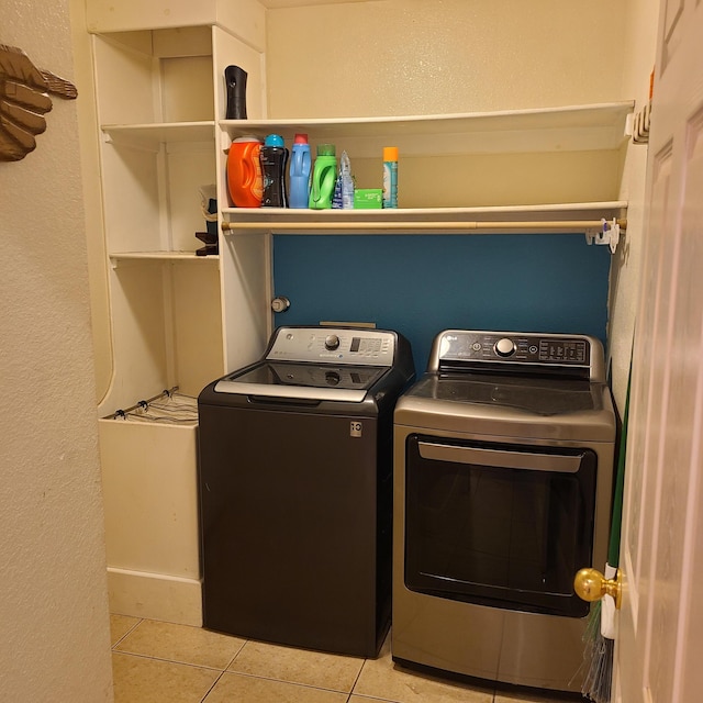 laundry room featuring light tile patterned floors and washer and clothes dryer