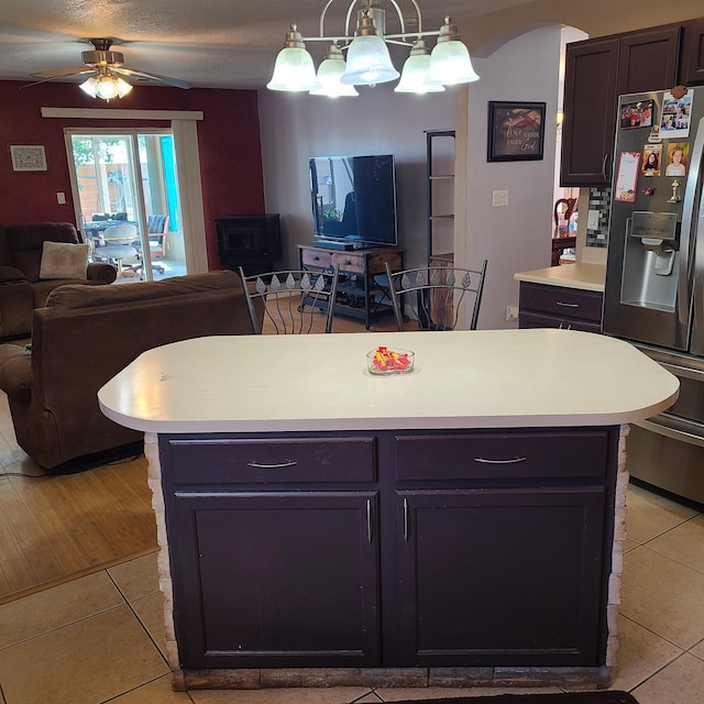 kitchen featuring hanging light fixtures, stainless steel refrigerator with ice dispenser, a kitchen island, and light tile patterned floors