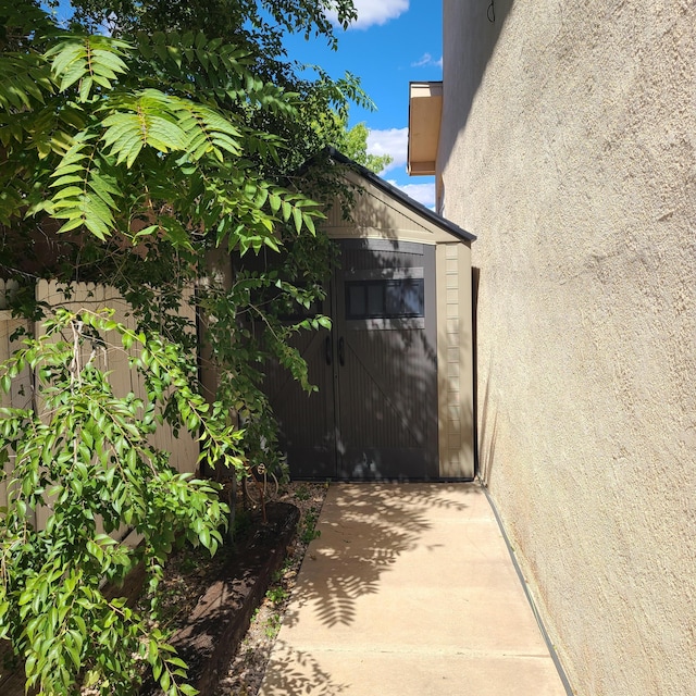 view of property exterior with a storage unit