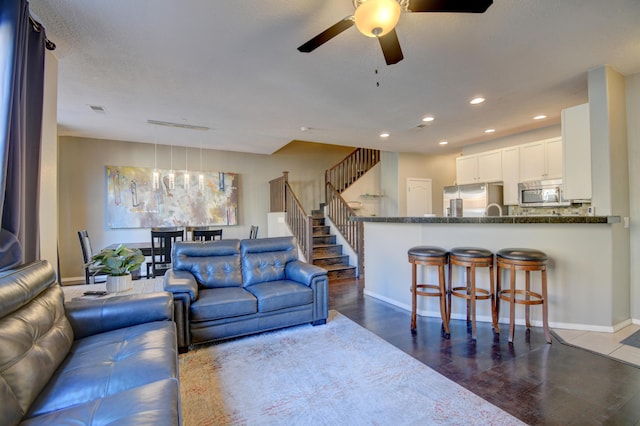 living room featuring ceiling fan and dark hardwood / wood-style floors