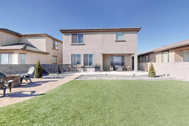 rear view of property featuring a lawn and a patio